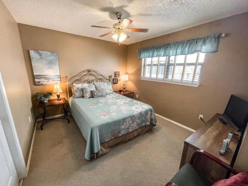 Un dormitorio con una cama y un ventilador de techo. en Texas River Condo, en New Braunfels