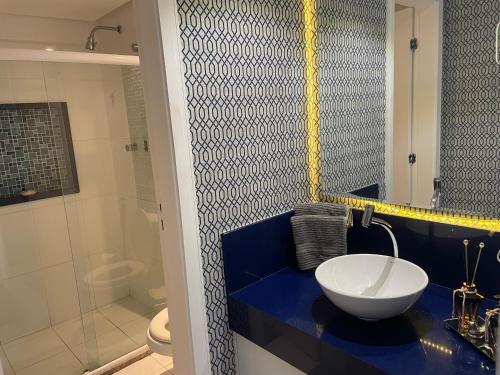 a bathroom with a blue counter with a sink and a shower at Cloc Marina Vista Mar p/ a Baía de Todos os Santos in Salvador