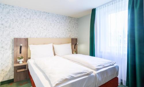 a bedroom with a large bed and a window at Hotel & Restaurant Hubertus Sehnde in Sehnde