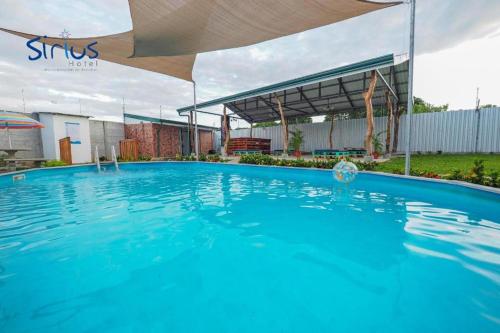 a large blue swimming pool with an umbrella at Hotel Sirius Costa Rica in San Mateo