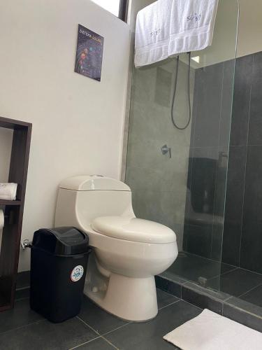 a bathroom with a toilet and a shower at Hotel Sirius Costa Rica in San Mateo
