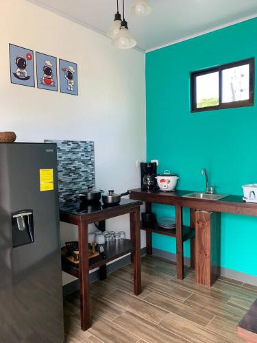 a kitchen with two tables and a blue wall at Hotel Sirius Costa Rica in San Mateo