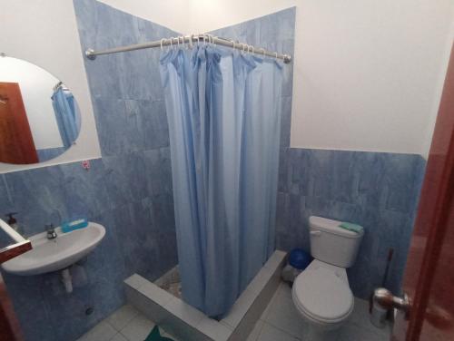 ein Badezimmer mit einem blauen Duschvorhang und einem WC in der Unterkunft Departamento familiar en Manta in Manta