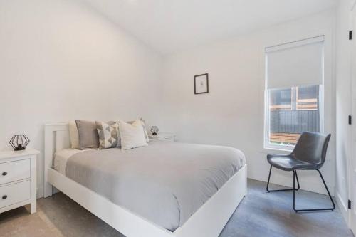 1 dormitorio blanco con 1 cama y 1 silla en Initial / Fika +spa / MSA en Saint-Férréol-les-Neiges