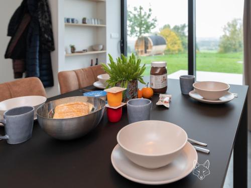 a table with bowls and plates on top of it at Tiny Fox Kluisbos in Mont-de-l'Enclus