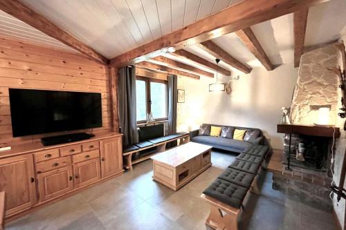 a living room with a couch and a flat screen tv at House type chalet - sauna and balneo - 14 pers in Gérardmer