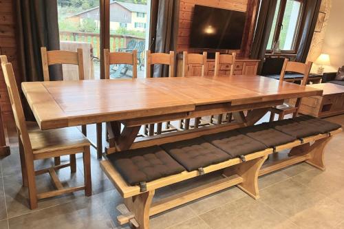 uma mesa e cadeiras de madeira com uma grande mesa e banco de madeira em House type chalet - sauna and balneo - 14 pers em Gérardmer