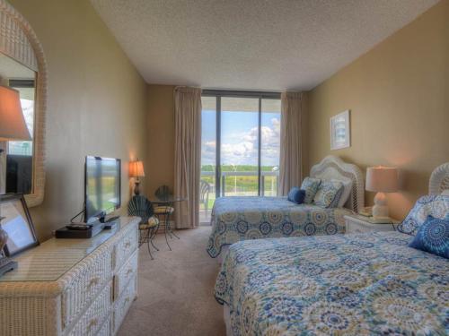 a hotel room with two beds and a television at Surfside Resort in Destin