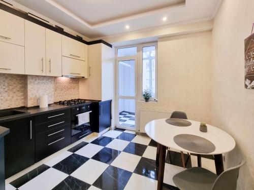 una cocina con suelo a cuadros en blanco y negro en Testemiteanu apartment, free wifi available, en Chişinău
