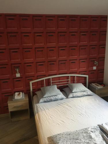ein Schlafzimmer mit einem Bett mit einer roten Wand in der Unterkunft "Na wesołej" in Tarnowitz