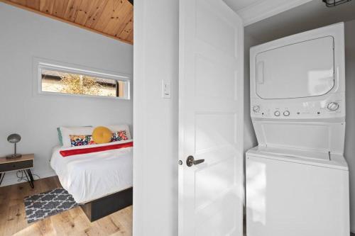 a small bedroom with a bed and a refrigerator at Initial / Mano / MSA in Saint-Férréol-les-Neiges