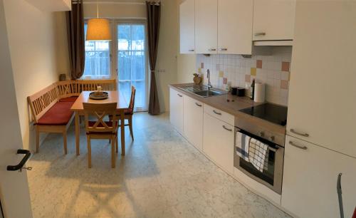 a kitchen with a table and a dining room at Hernegg Apartment in Riscone
