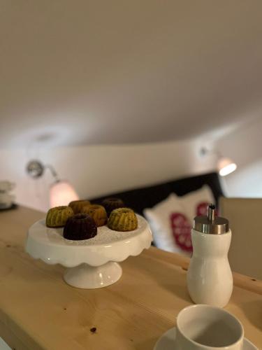 a table with a plate of donuts and a vase at Pension Steinkogel in Sankt Leonhard im Pitztal