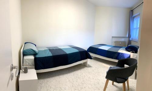 里斯孔內的住宿－Hernegg Apartment，一间设有两张床和椅子的房间