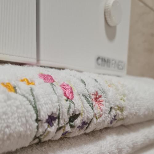 ein Handtuch mit Blumen auf einem Regal in der Unterkunft Apartman TIM LUX 1 in Vrnjačka Banja