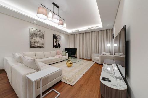 ドバイにあるParamount Midtown Luxury 2 Bedroom With Full Burj-Khalifa Viewのリビングルーム(白いソファ、テーブル付)