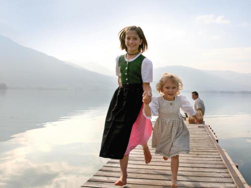 two children are standing on a dock on the water at Das Franzl - Bett & Brot in St. Wolfgang