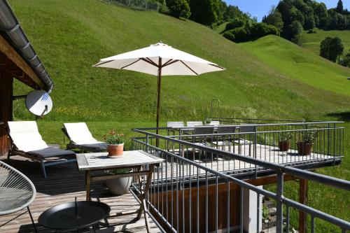 a patio with a table and an umbrella at Ferienwohnung Lingg in Schoppernau