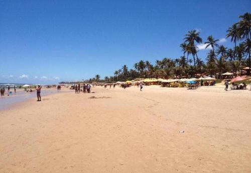 a group of people on a beach with palm trees at Sol de Bora Bora 101 in Salvador