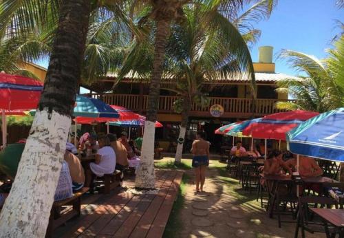 a group of people sitting at tables under umbrellas at Sol de Bora Bora 101 in Salvador