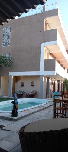 a building with a swimming pool with a fire hydrant at Pousada paraiso das dunas in Cumbuco