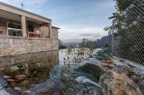 a pool of water in front of a building at Casa de Campo Sossego da Lata in Fafe