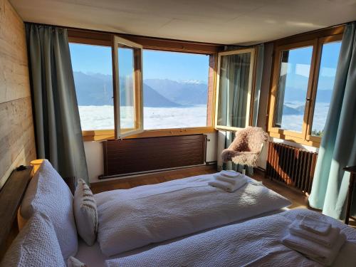 ein Schlafzimmer mit einem großen Bett und einem großen Fenster in der Unterkunft Hotel Bergsonne Rigi in Rigi Kaltbad