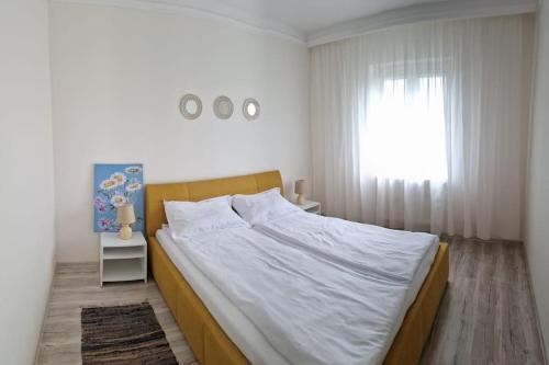 1 dormitorio con 1 cama blanca grande y ventana en ORI Modern Apart Malul Muresului , Arad en Arad