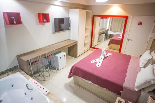 a room with a bed and a bath tub at Pousada Orla dos Corais in Maragogi