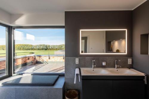 a bathroom with a sink and a large window at Luxus Penthouse mit Kamin und Sonnenterasse in Bedburg Hau