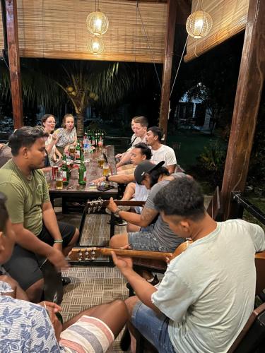 a group of people sitting around a table playing chess at Gino's Place - Guest House & Jungle Trekking in Bukit Lawang