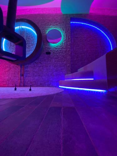 a room with purple and blue lights and a brick wall at ilpostonascosto in Isernia