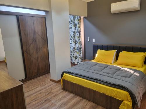 ein Schlafzimmer mit einem Bett mit gelben Kissen in der Unterkunft Elite apartment in Mohandessin in Kairo