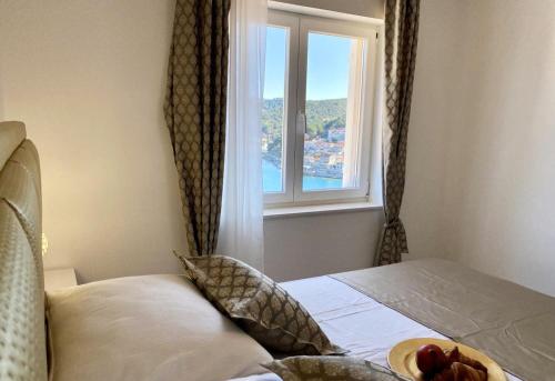 a bedroom with a window with a bowl of fruit on a bed at Villa FJERA - sea view, hot tubs, terrace, BBQ in Pučišća