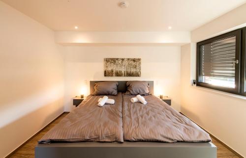 a bedroom with a large bed with two pillows at Luxus Penthouse mit Kamin und Sonnenterasse in Bedburg Hau