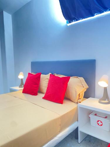 a bedroom with a bed with two red pillows at Best Rooms- Quarto 4 Plateau in Praia