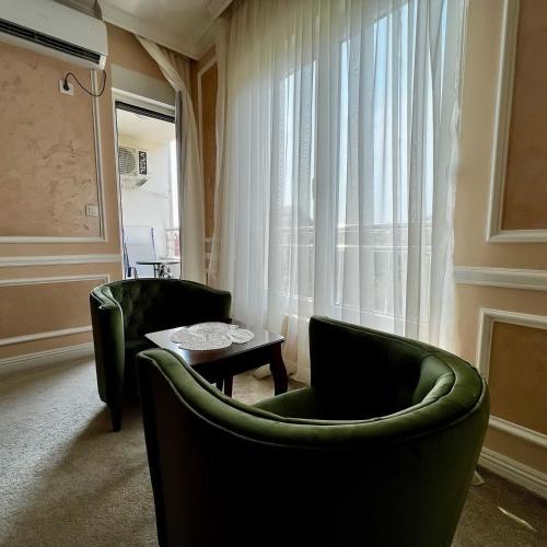 a living room with two green chairs and a table at Budva Centar in Budva