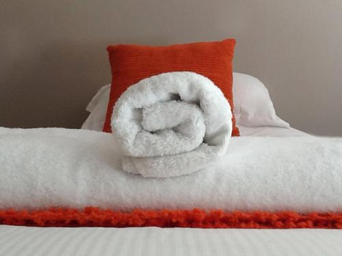 uma toalha branca numa cama com uma almofada em Garden Cottage Bed and Breakfast em Holton