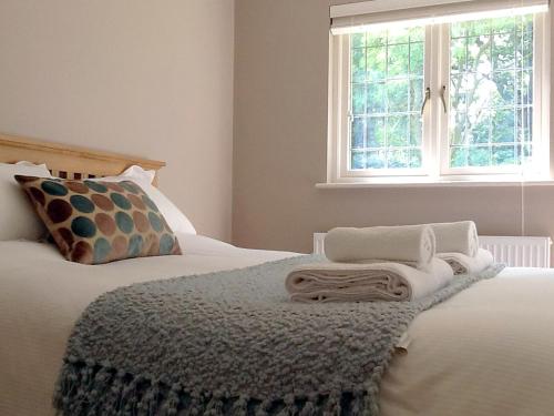 a bedroom with a bed with a blanket and a window at Garden Cottage Bed and Breakfast in Holton