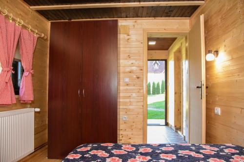 um quarto com uma cama e uma parede de madeira em Brvnara Brkovic 2 em Čajetina