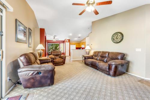 a living room with leather furniture and a ceiling fan at Good Times in Goodyear in Goodyear
