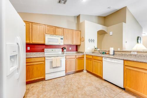 a kitchen with white appliances and wooden cabinets at Good Times in Goodyear in Goodyear