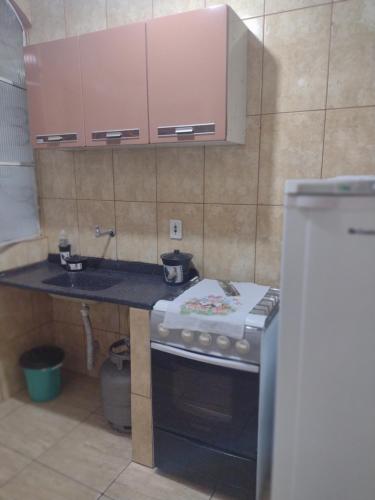 a small kitchen with a stove and a sink at Kitnet completa in Guaratinguetá