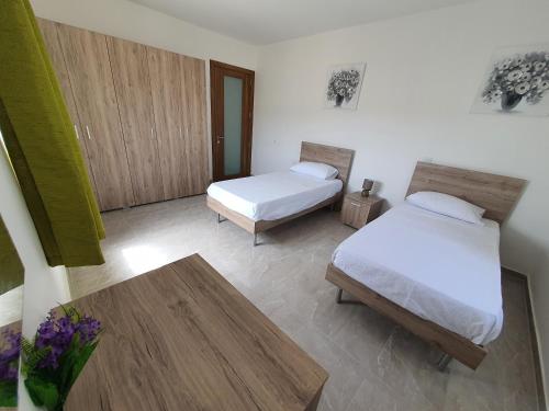 a bedroom with two beds and a coffee table at Pretty 2 bedroom Apartment with shared Pool in St. Paul's Bay
