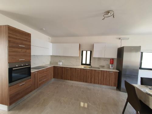 a kitchen with wooden cabinets and stainless steel appliances at Pretty 2 bedroom Apartment with shared Pool in St. Paul's Bay