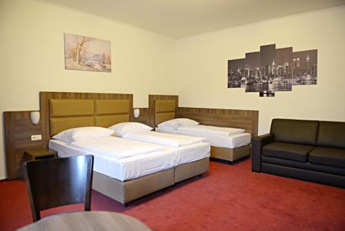 une chambre d'hôtel avec deux lits et un canapé dans l'établissement ITM Hotel Motel21 Hamburg-Mitte, à Hambourg