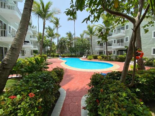 un complejo con piscina con palmeras y edificios en Ducassi Sol Caribe Beach, en Punta Cana