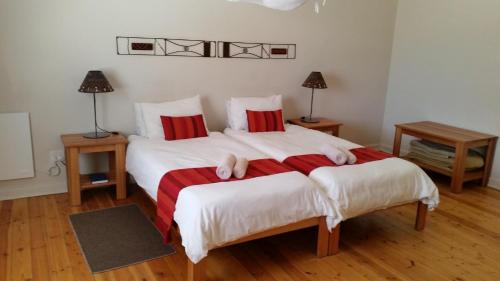 a bedroom with two beds with red and white sheets at Bahnhof Hotel Aus in Aus
