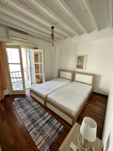 a bedroom with a bed and a table and a window at Myconian Avra Apartment in Megali Ammos