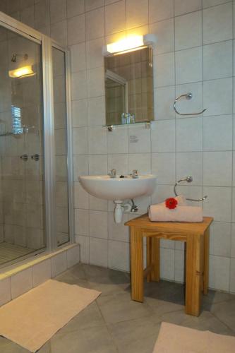 a bathroom with a sink and a shower at Bahnhof Hotel Aus in Aus